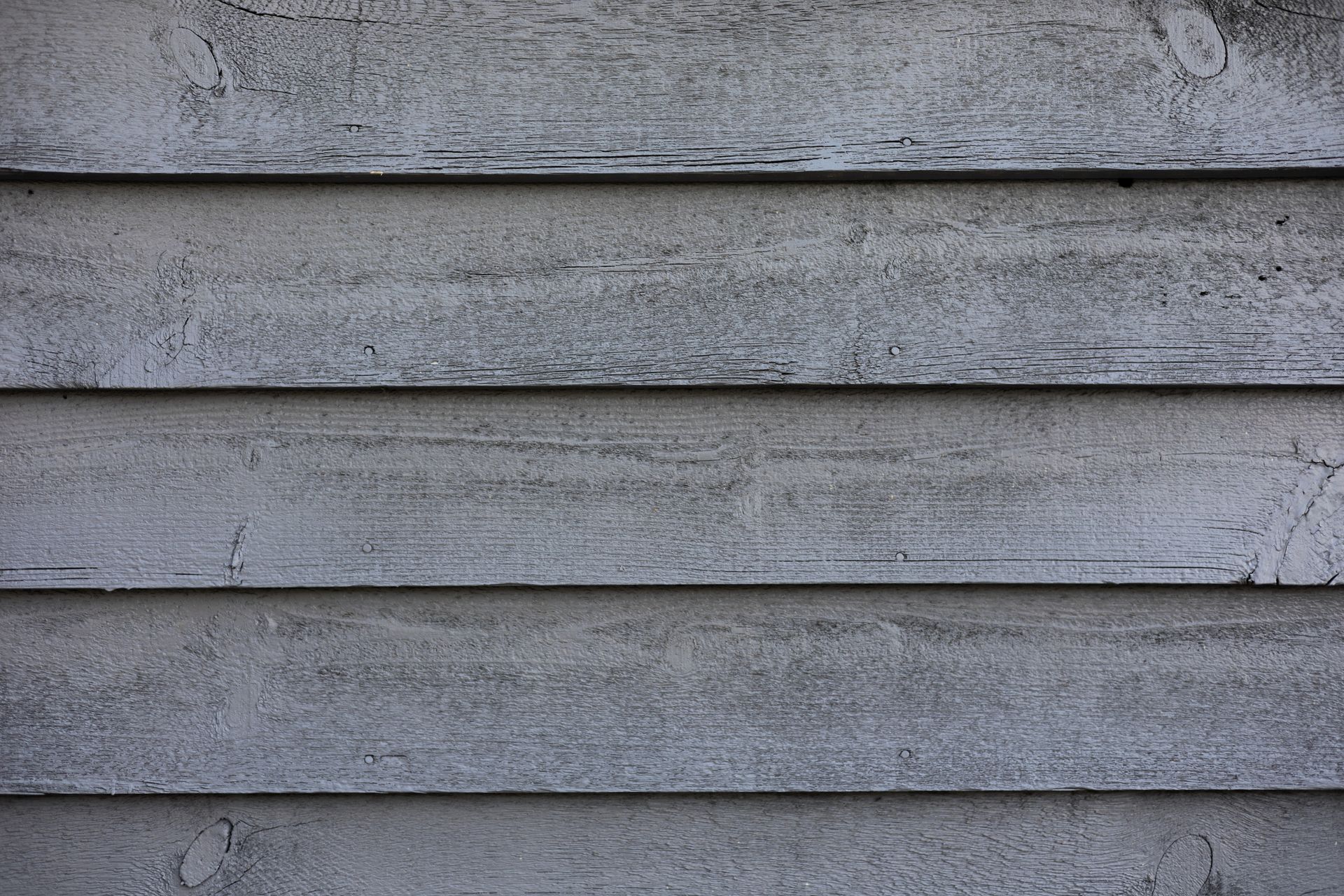 Gray painted wooden siding. Horizontal planks with visible grain.