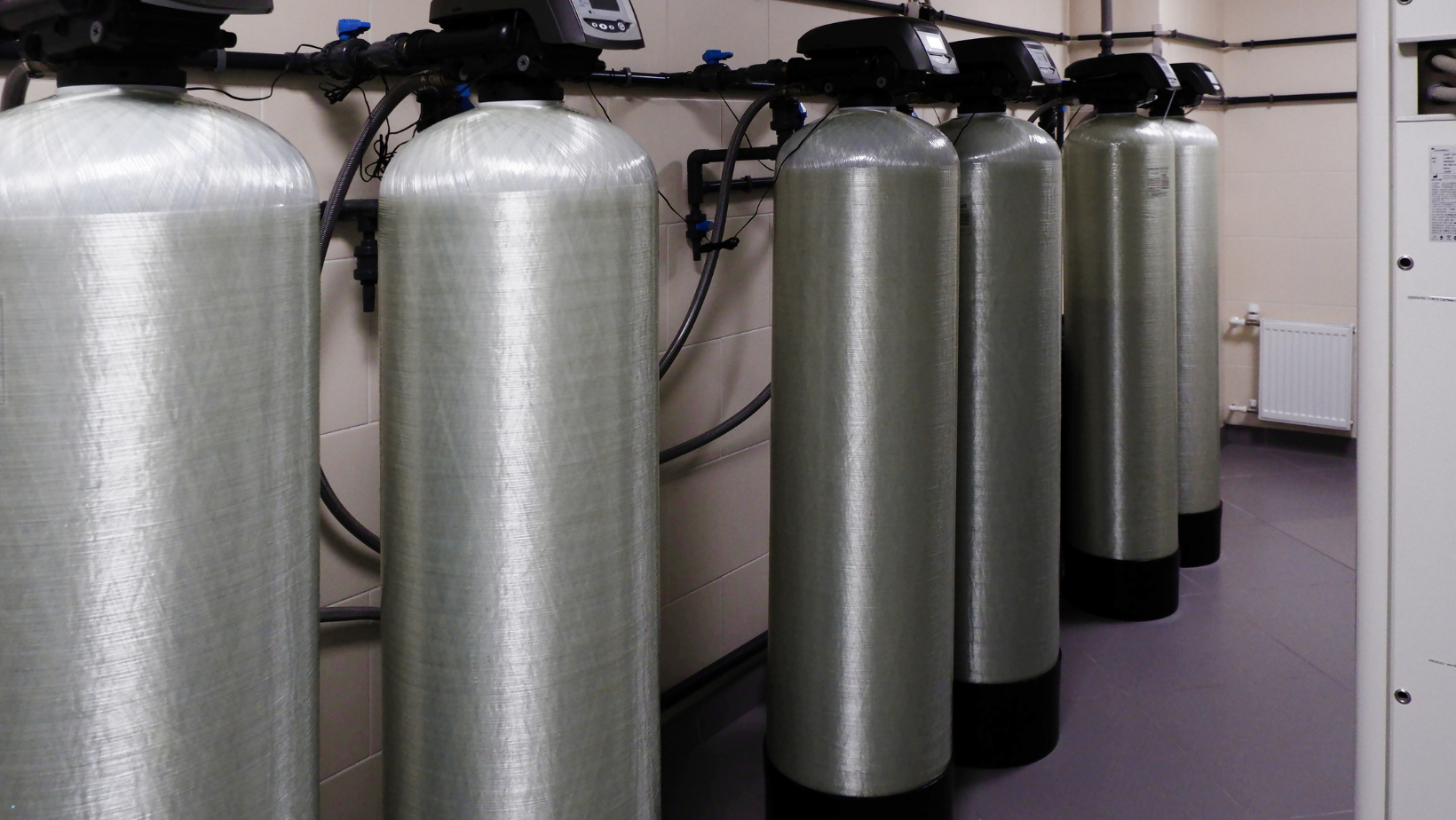 A row of water filters are lined up in a room.