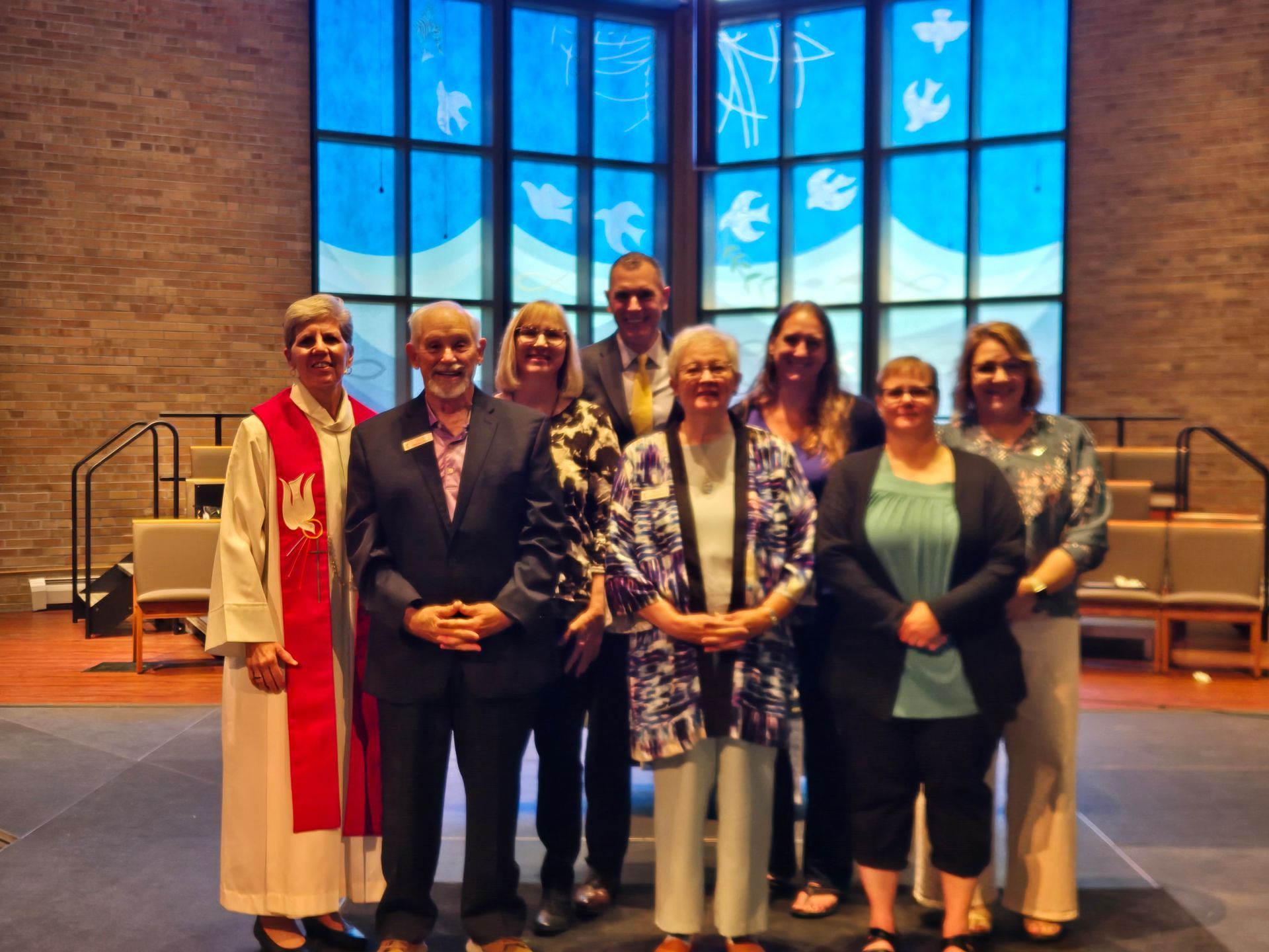 A group of people standing in front of a stained glass window