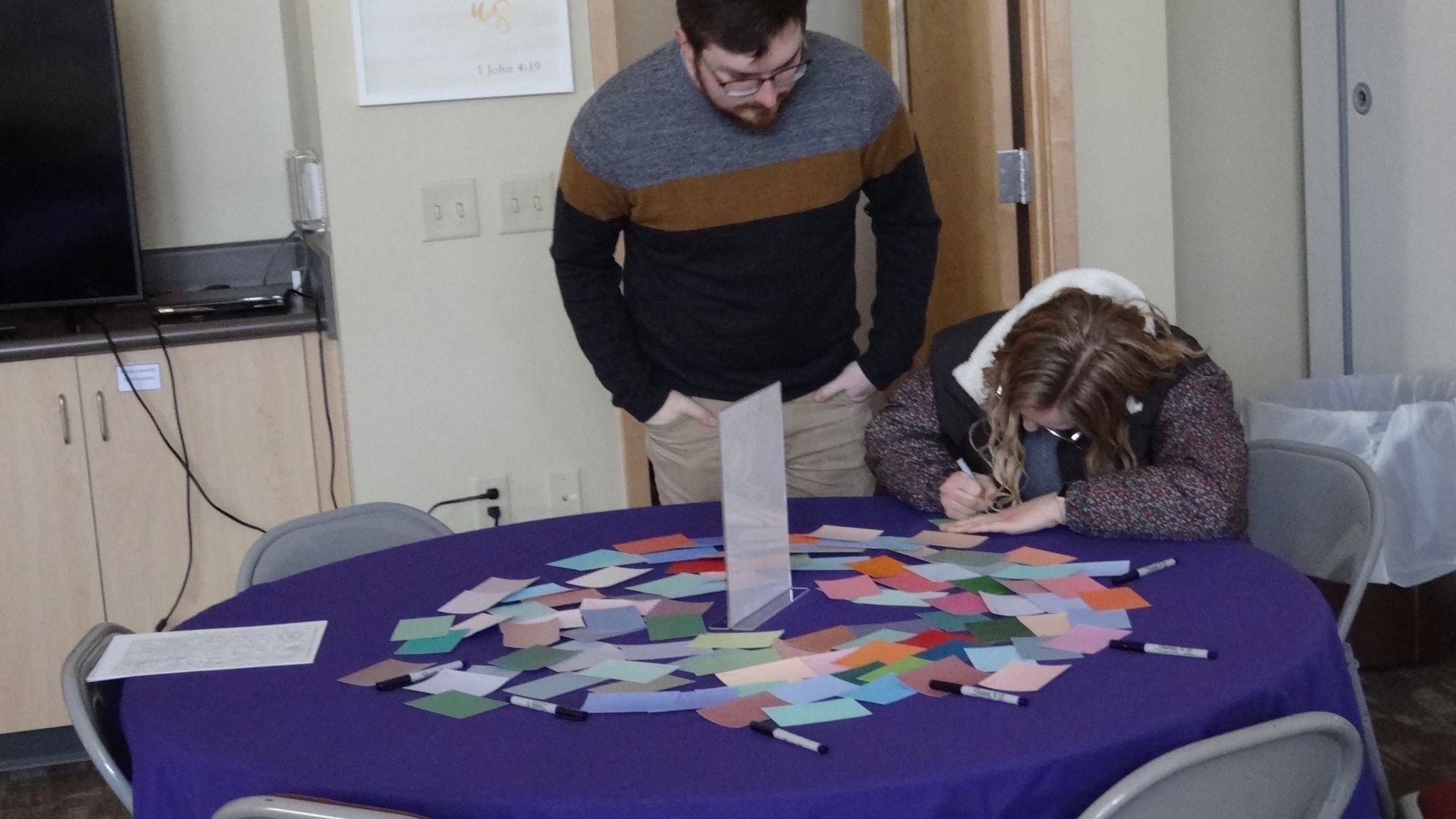 A man and a woman are sitting at a table with papers on it.