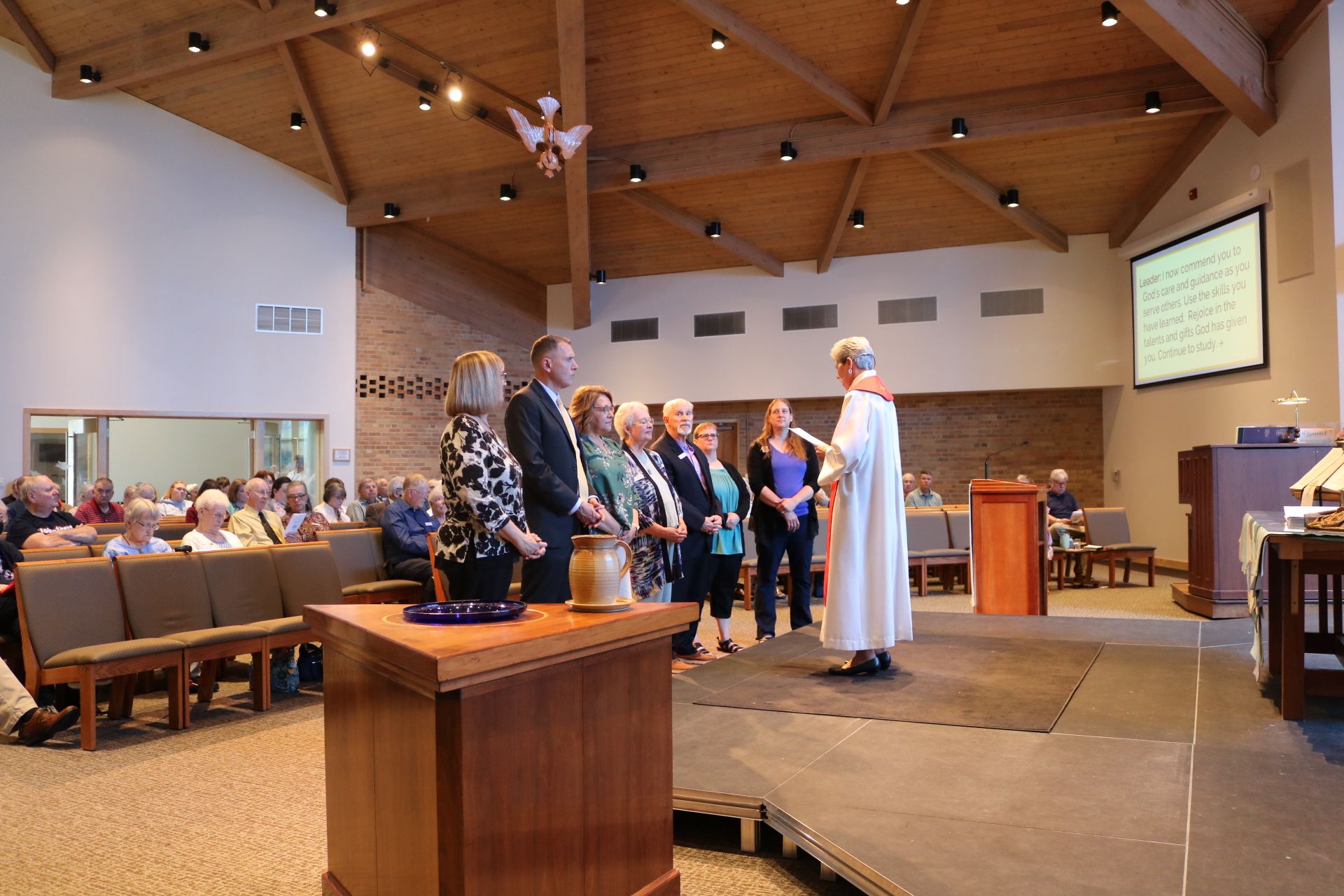 A group of people are standing around a podium in a church.