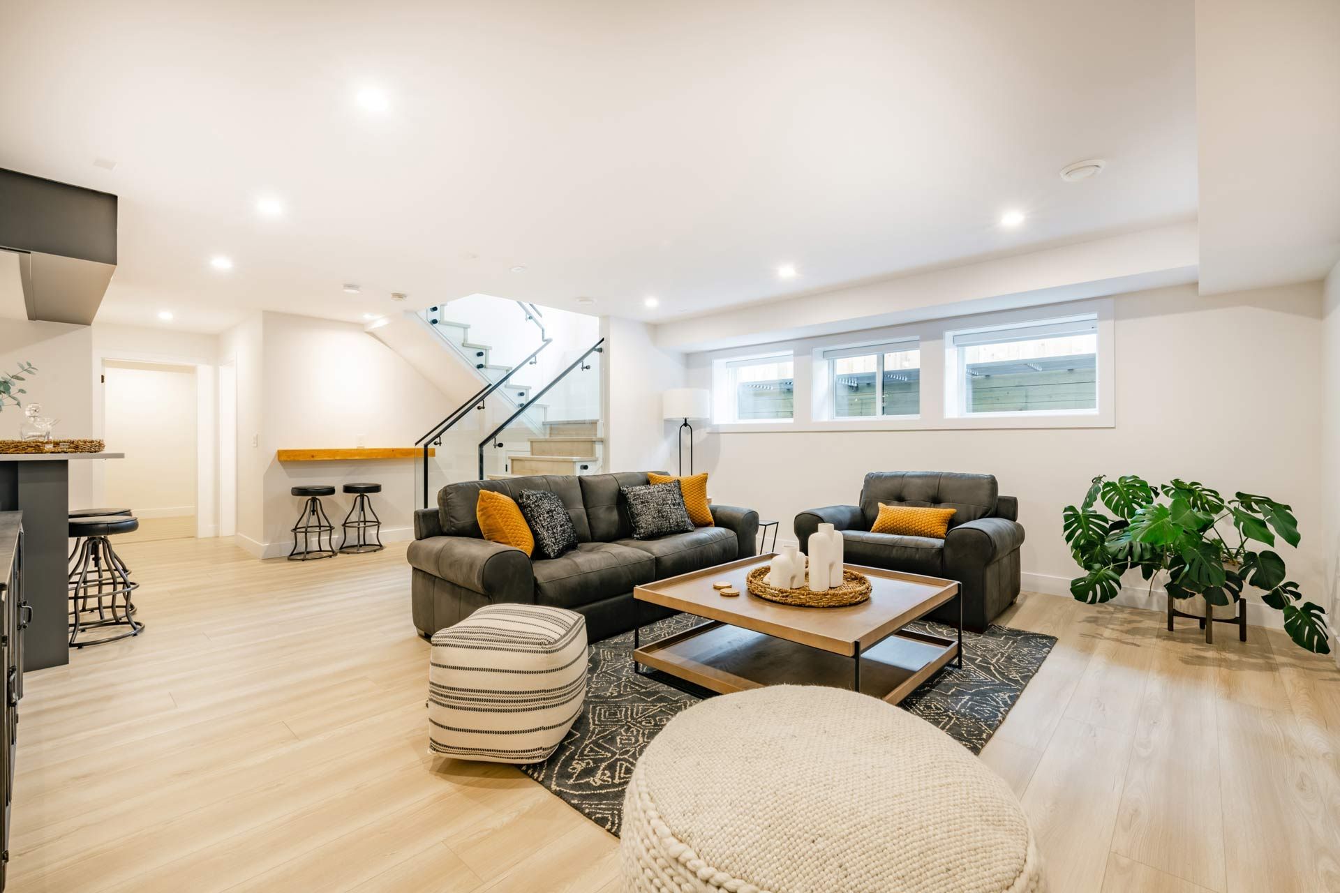 A living room with two couches , a coffee table , and a staircase.