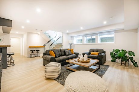 A living room with two couches , a coffee table , and a staircase.