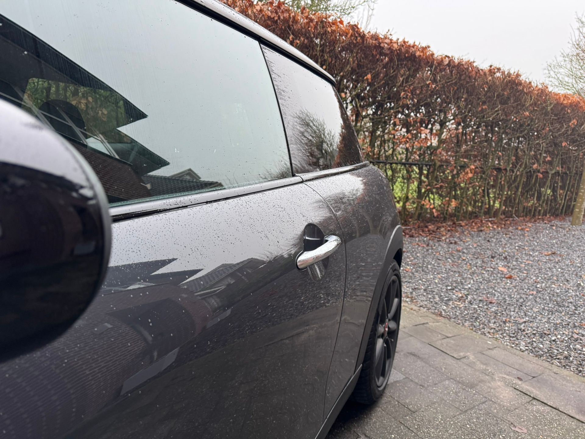 Donkergrijze Mini Cooper met zwarte raamlijsten 