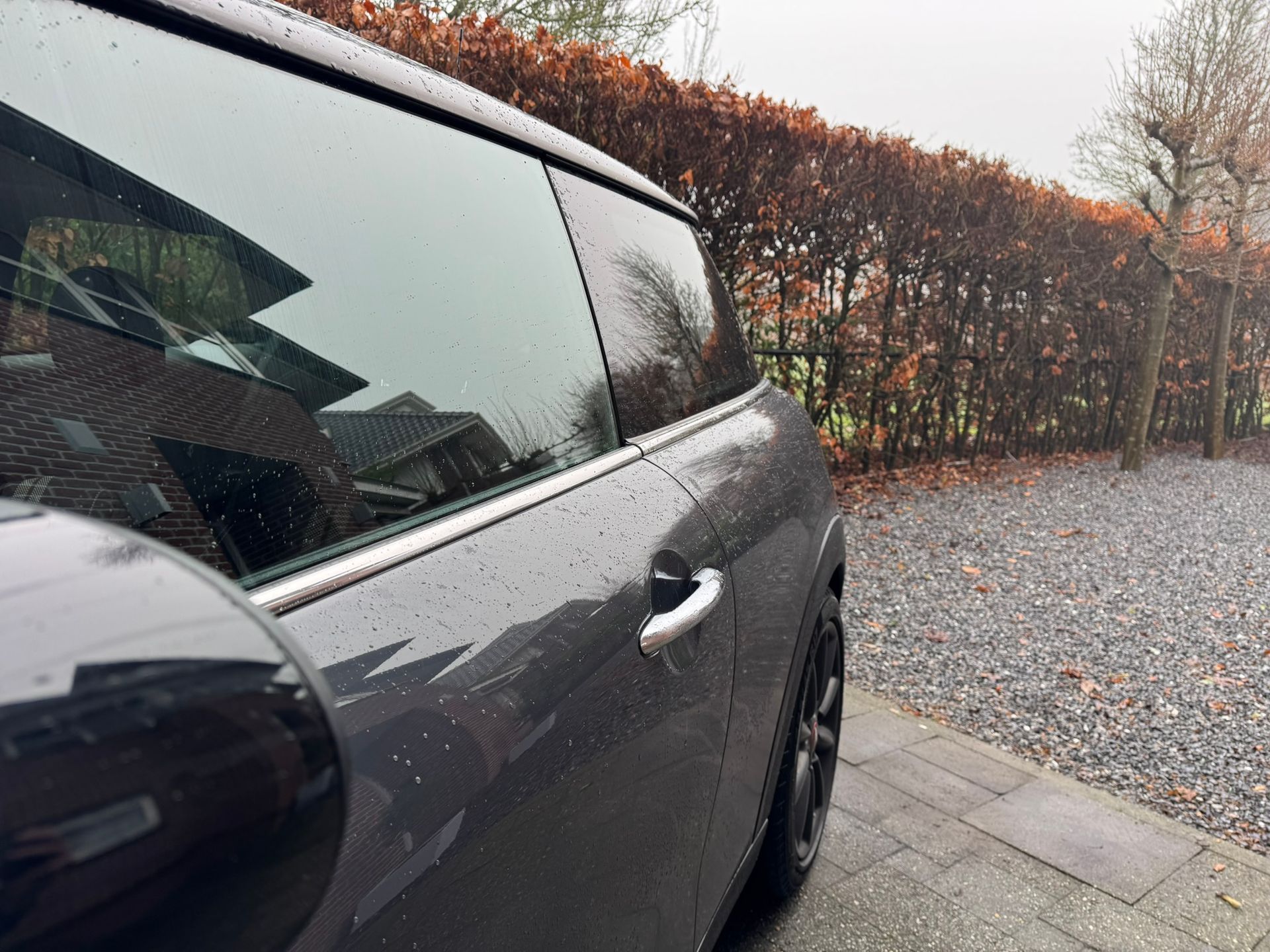 Donkergrijze Mini Cooper met chrome raamlijsten 
