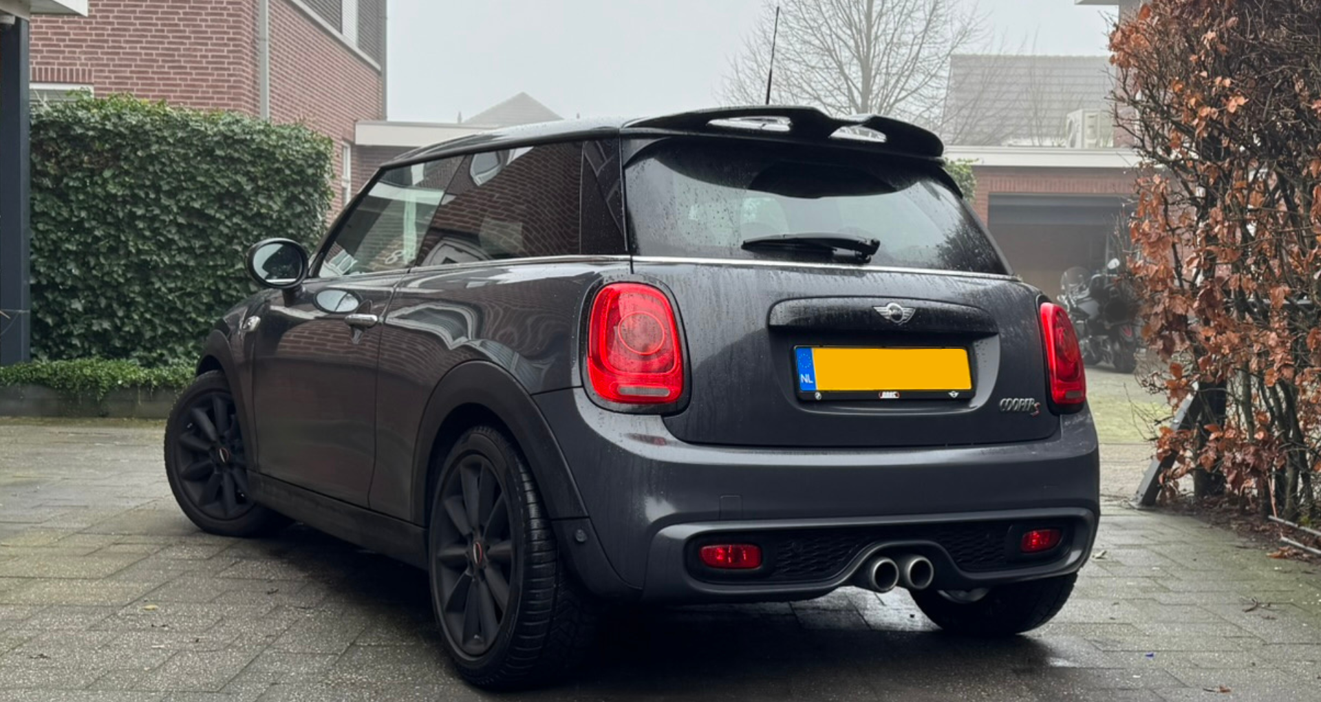 Donkergrijze Mini Cooper met chrome raamlijsten