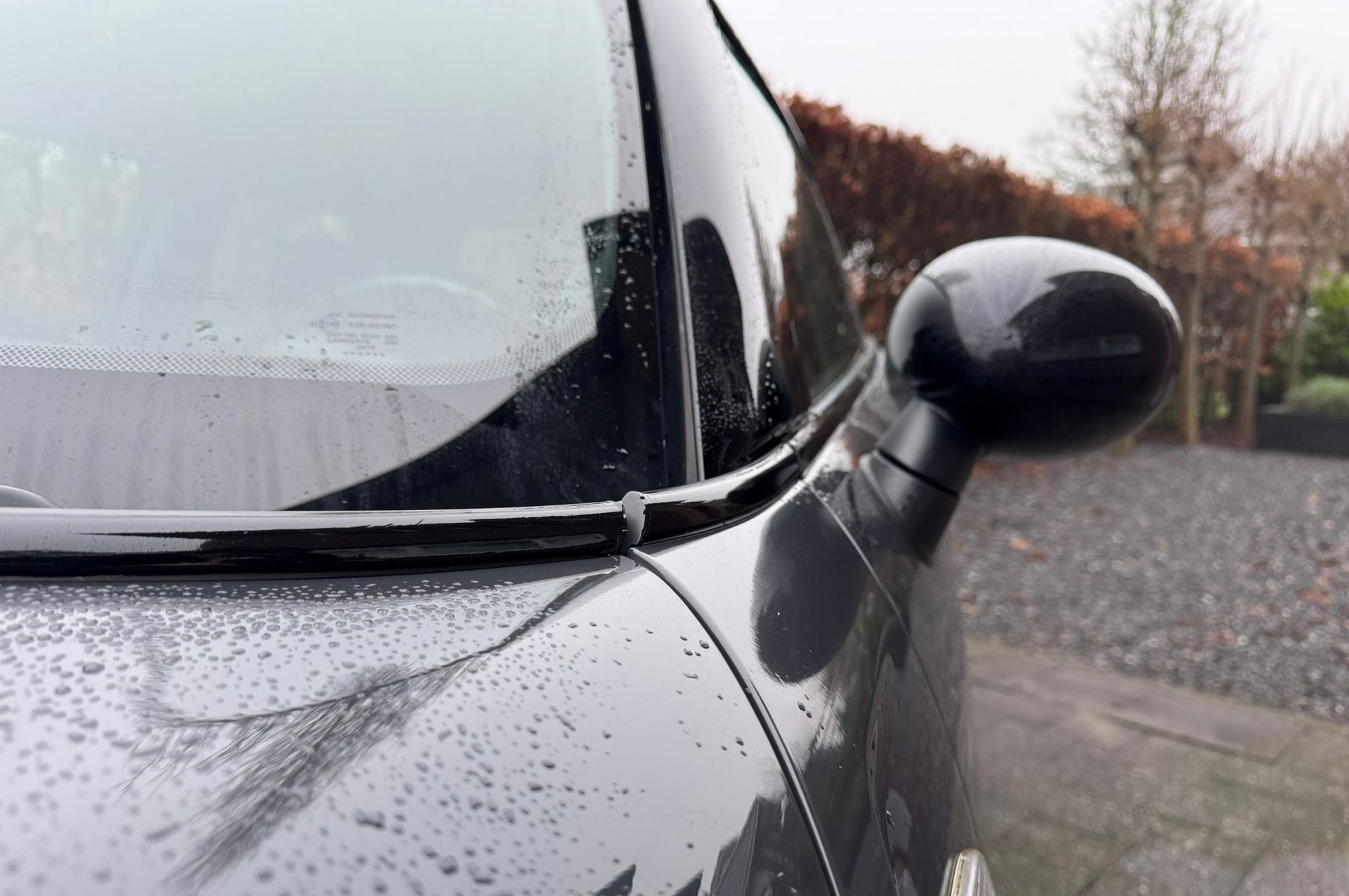 Donkergrijze Mini Cooper met zwarte raamlijsten 