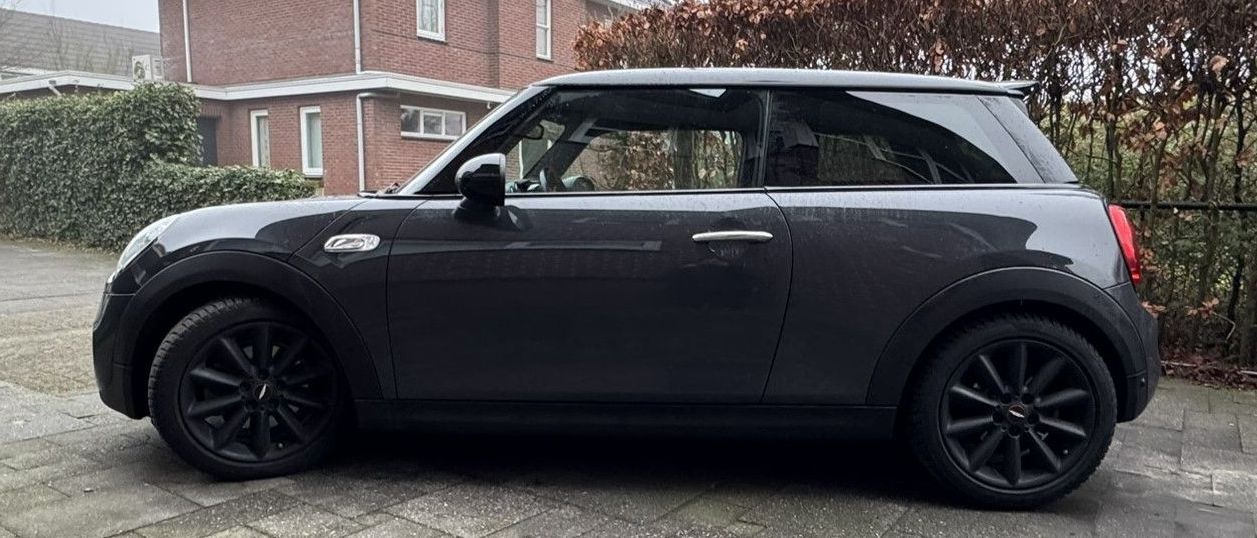 Donkergrijze Mini Cooper met zwarte raamlijsten 