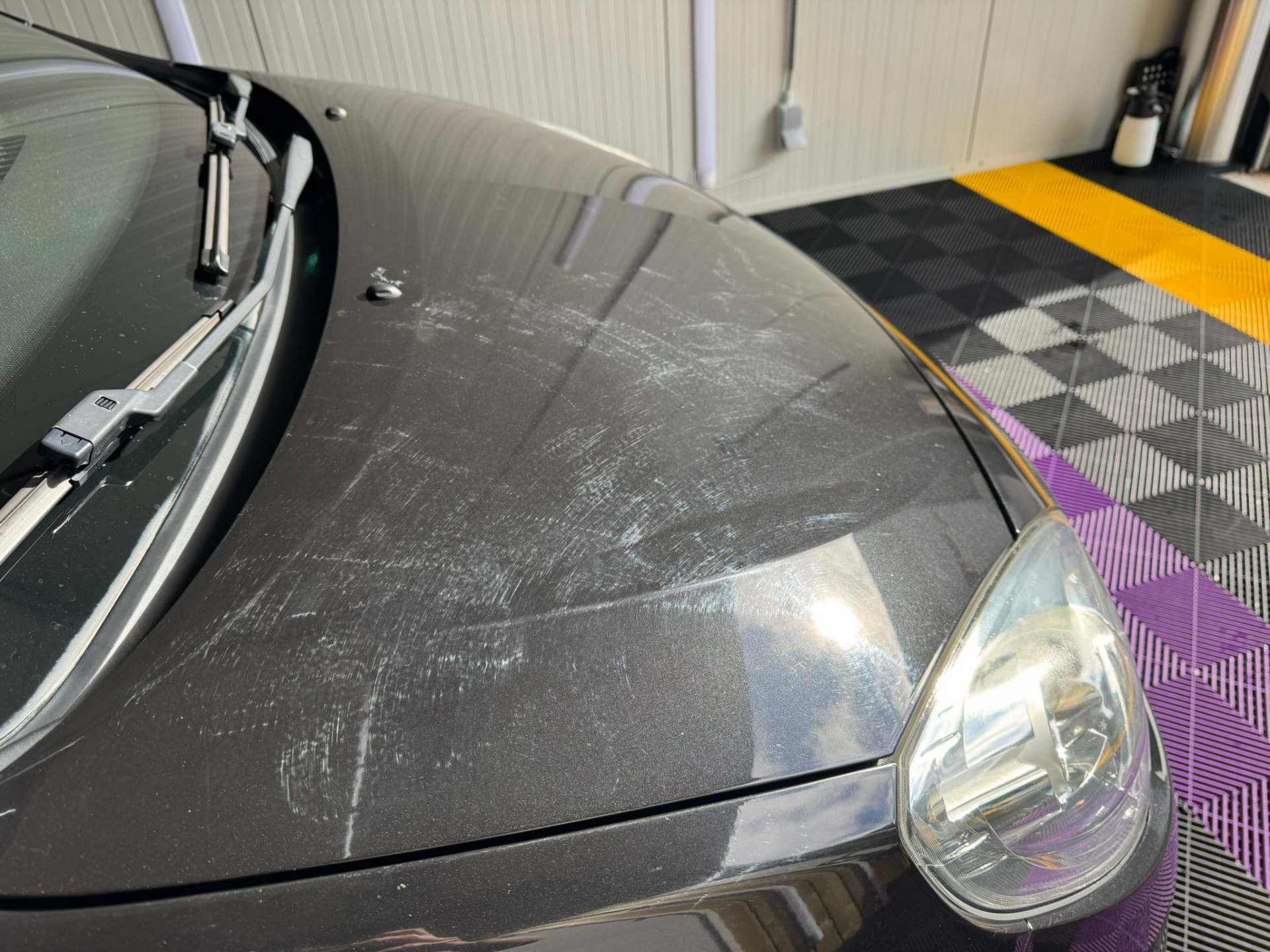 Zwarte auto met veel swirls en oxidatie