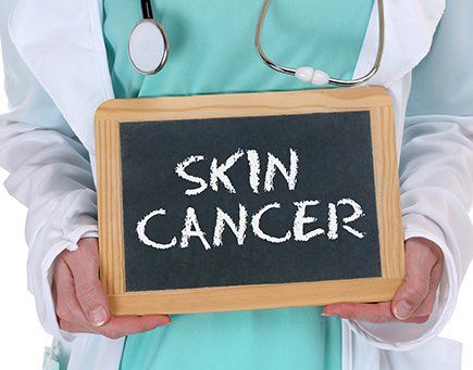 Mohs Surgery — Doctor Holding Skin Cancer Signboard in Greenville, SC
