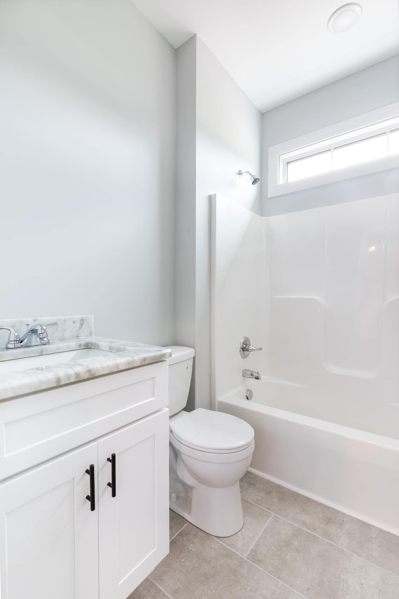A bathroom with a toilet , sink and bathtub.