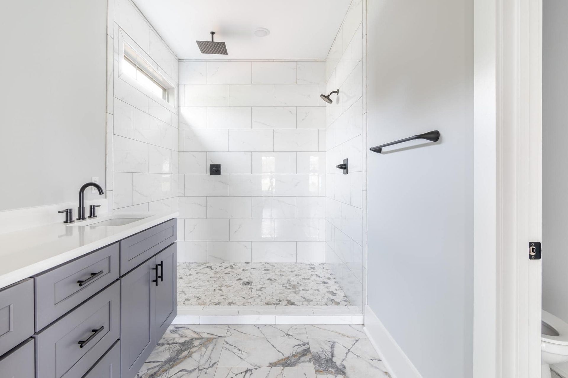 A bathroom with a walk in shower and a sink.