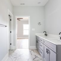 A bathroom with two sinks and a marble floor.