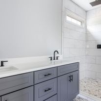 A bathroom with a sink , mirror , and shower.