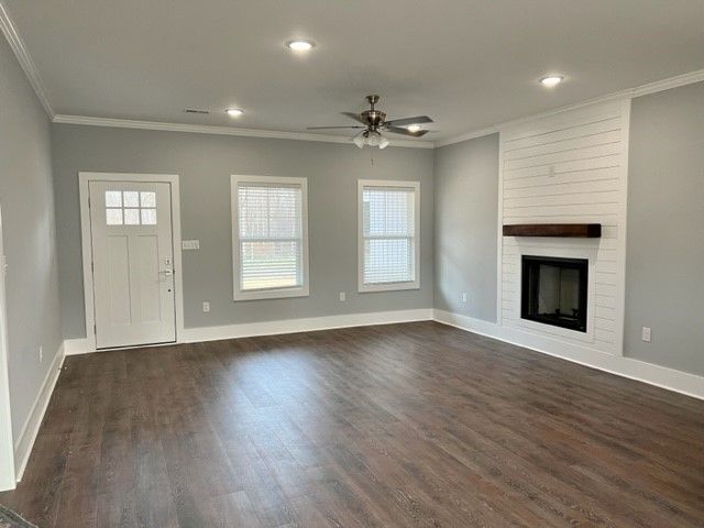 An empty living room with hardwood floors and a fireplace.
