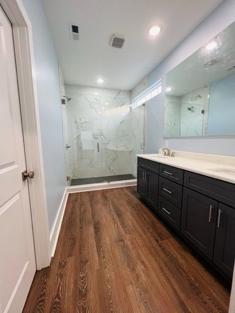 A bathroom with a walk in shower , sink , and mirror.