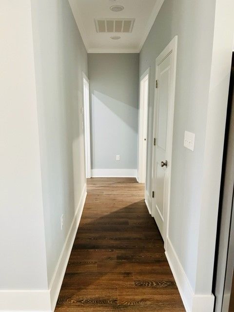 A long hallway with wood floors and white trim