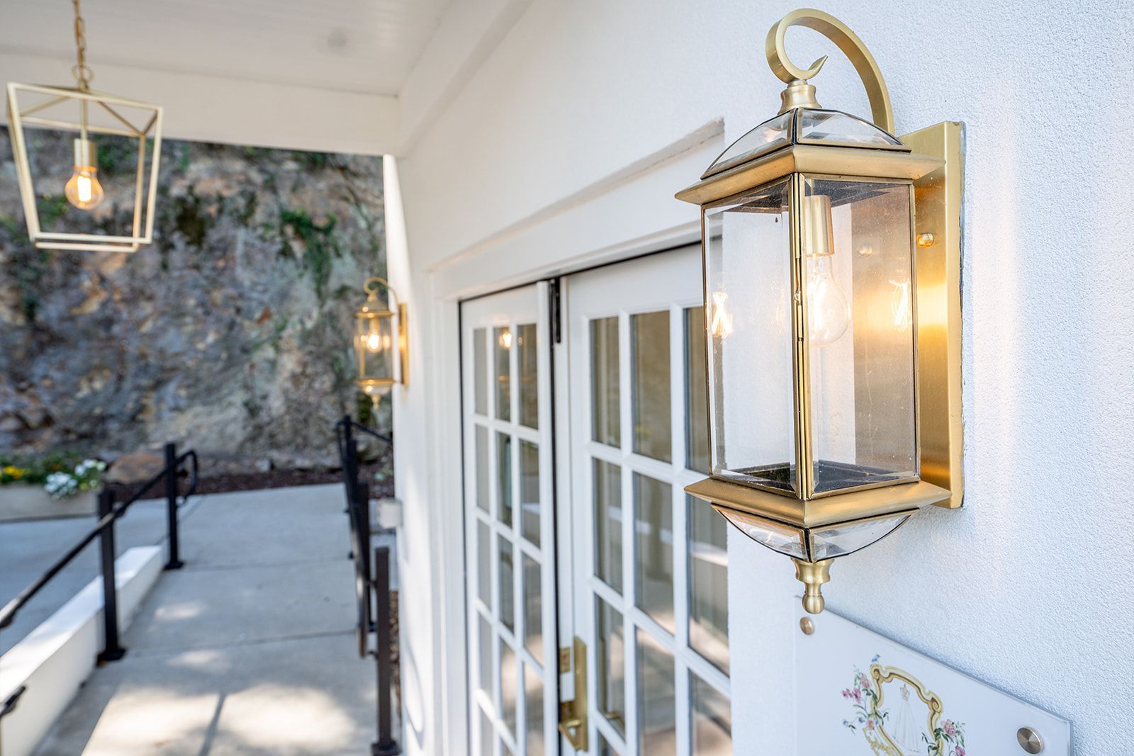 A lantern is hanging on the side of a building next to a door.