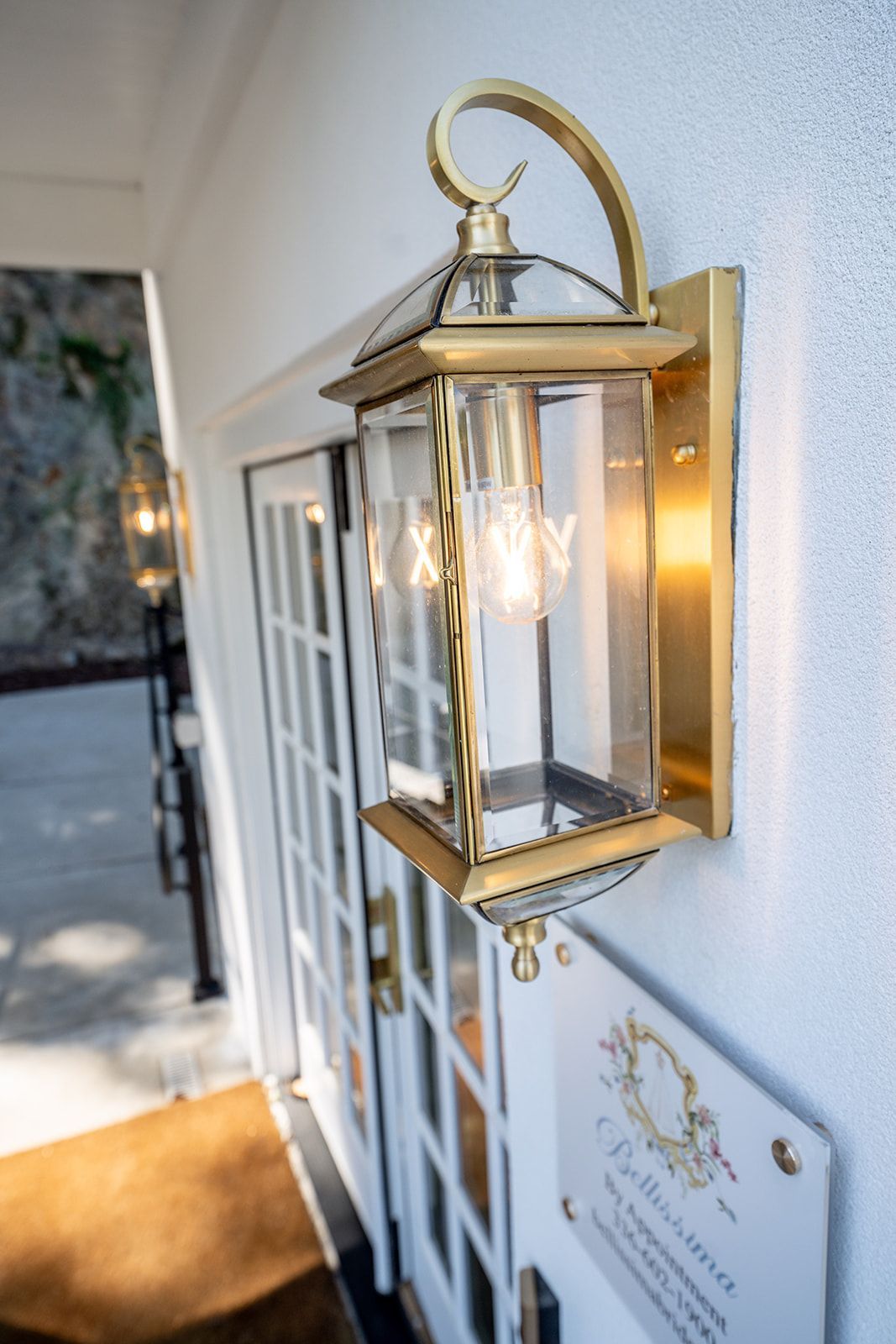 A lantern is hanging on the side of a building next to a door.
