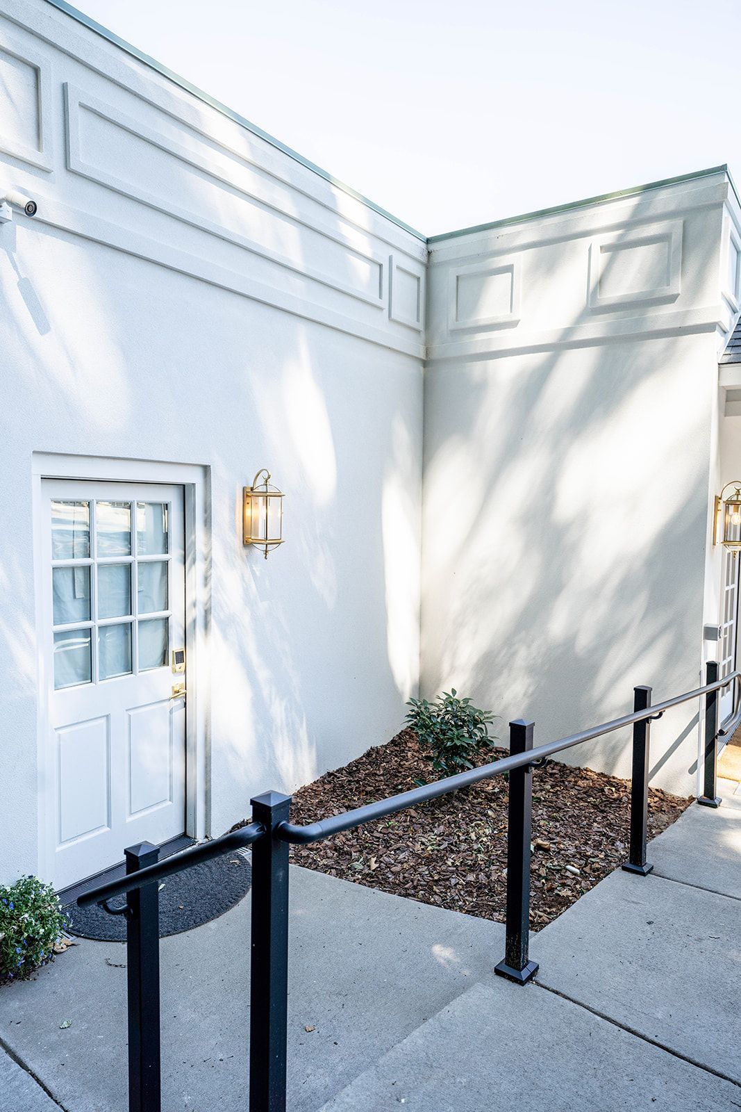 A white building with a door and stairs leading to it