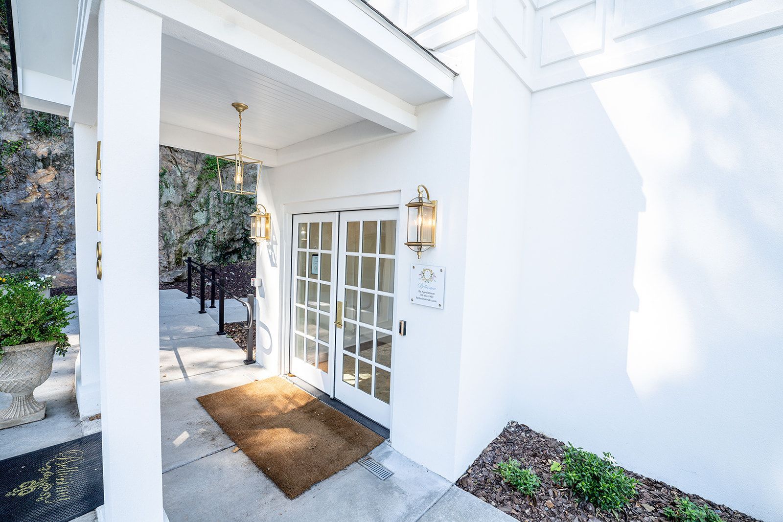 A white house with a porch and sliding glass doors.