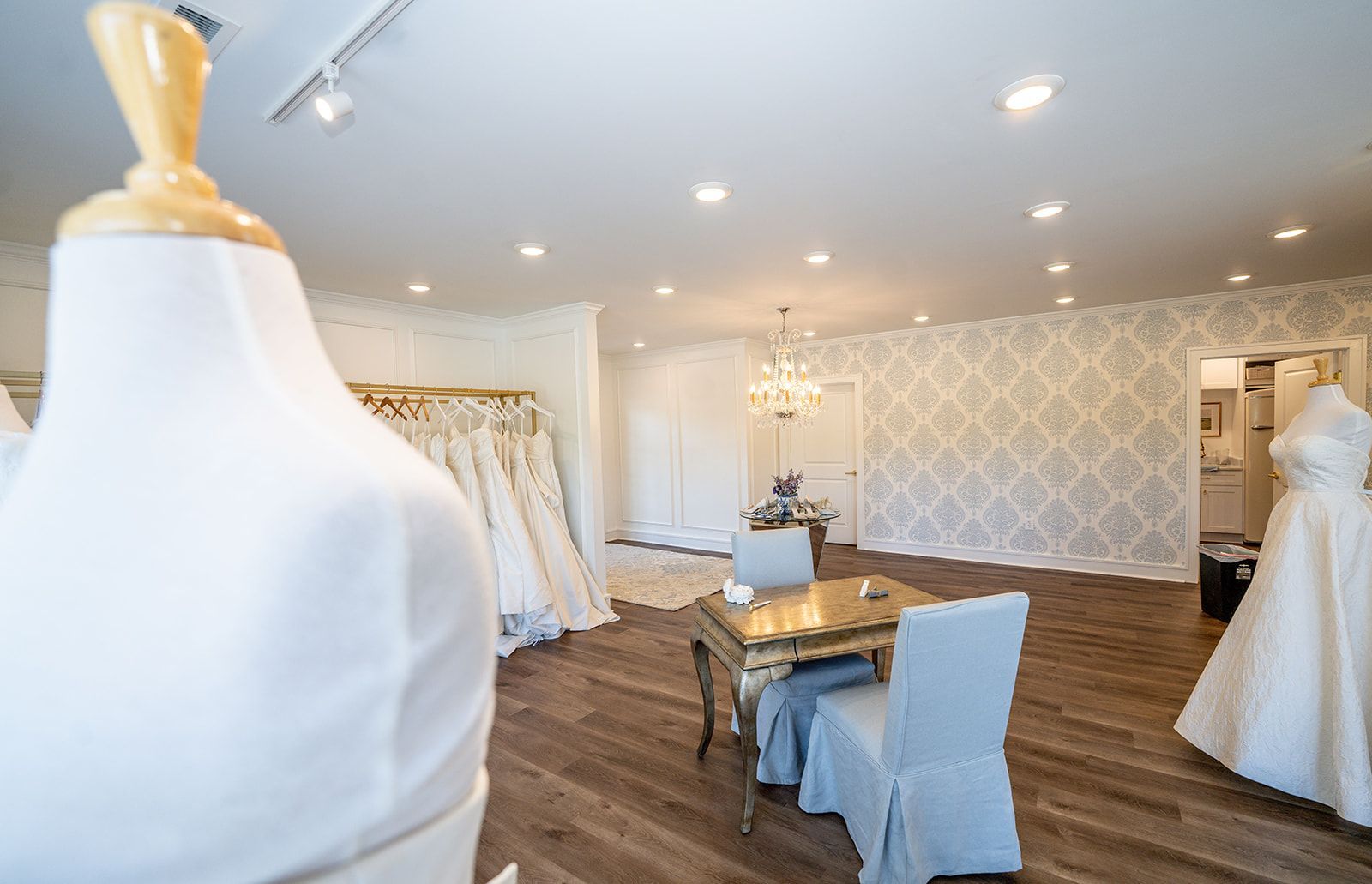 A room filled with lots of wedding dresses and a table.