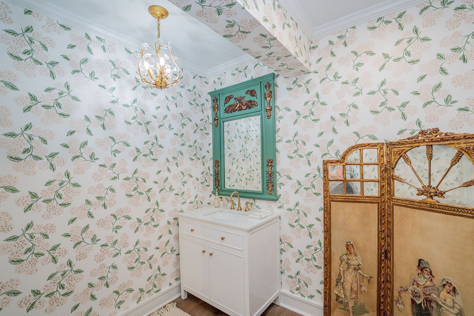 A bathroom with a sink , mirror , and painting on the wall.