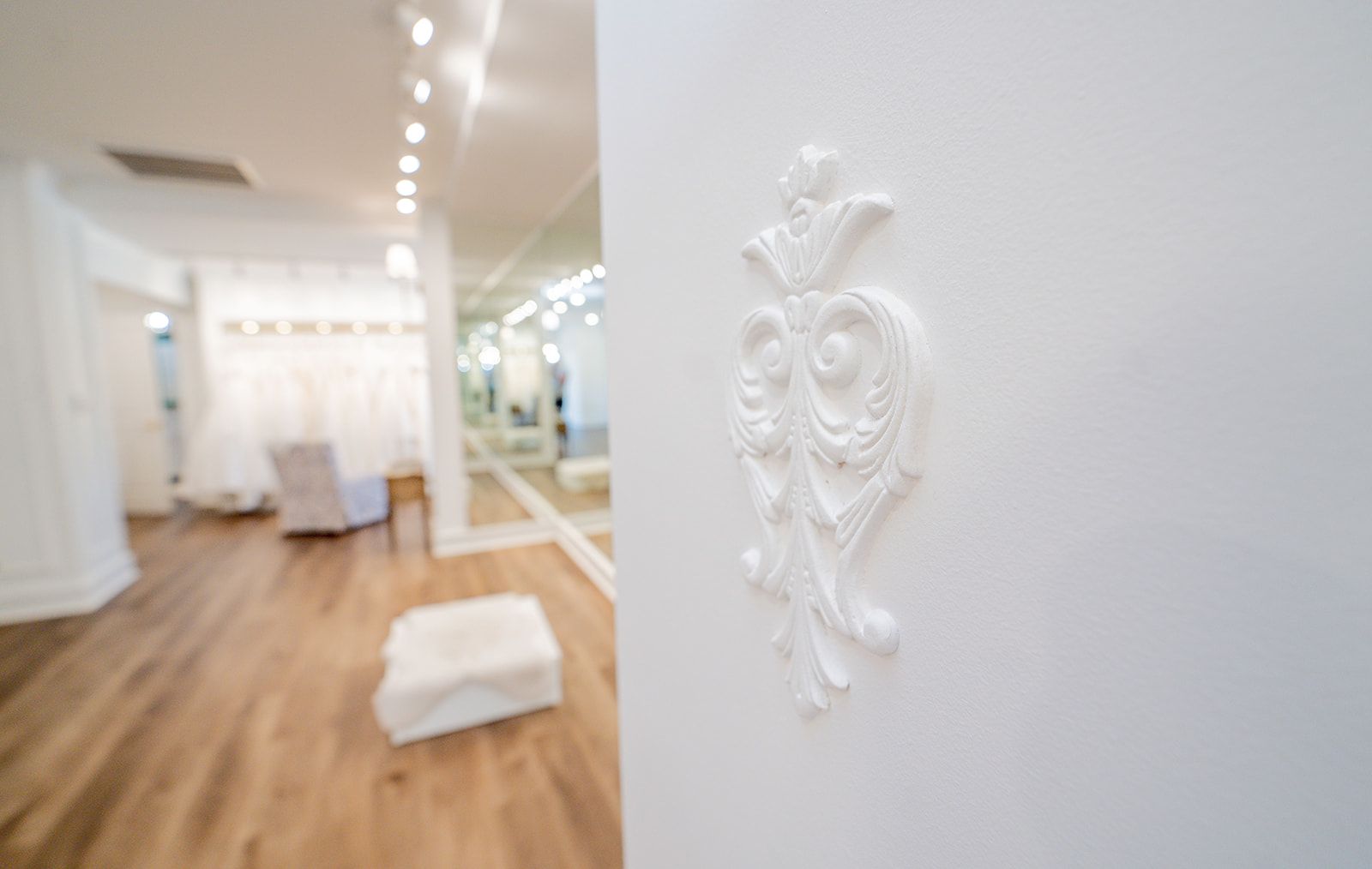 A white door with a floral design on it in a room with a wooden floor.