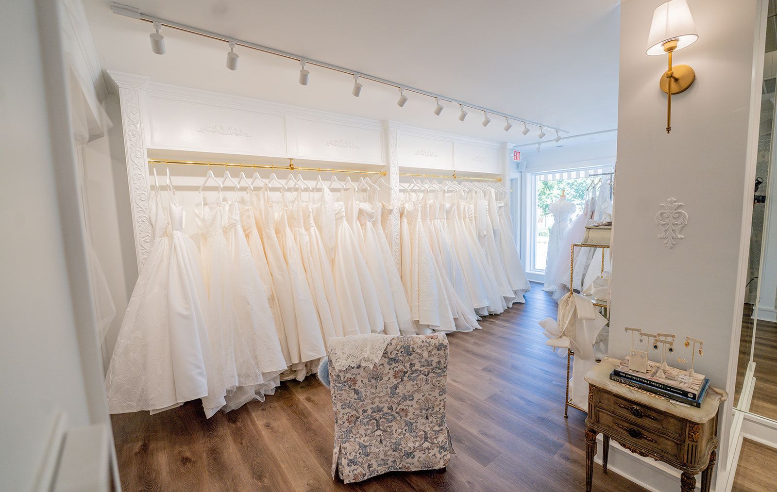 A room filled with lots of wedding dresses on display.