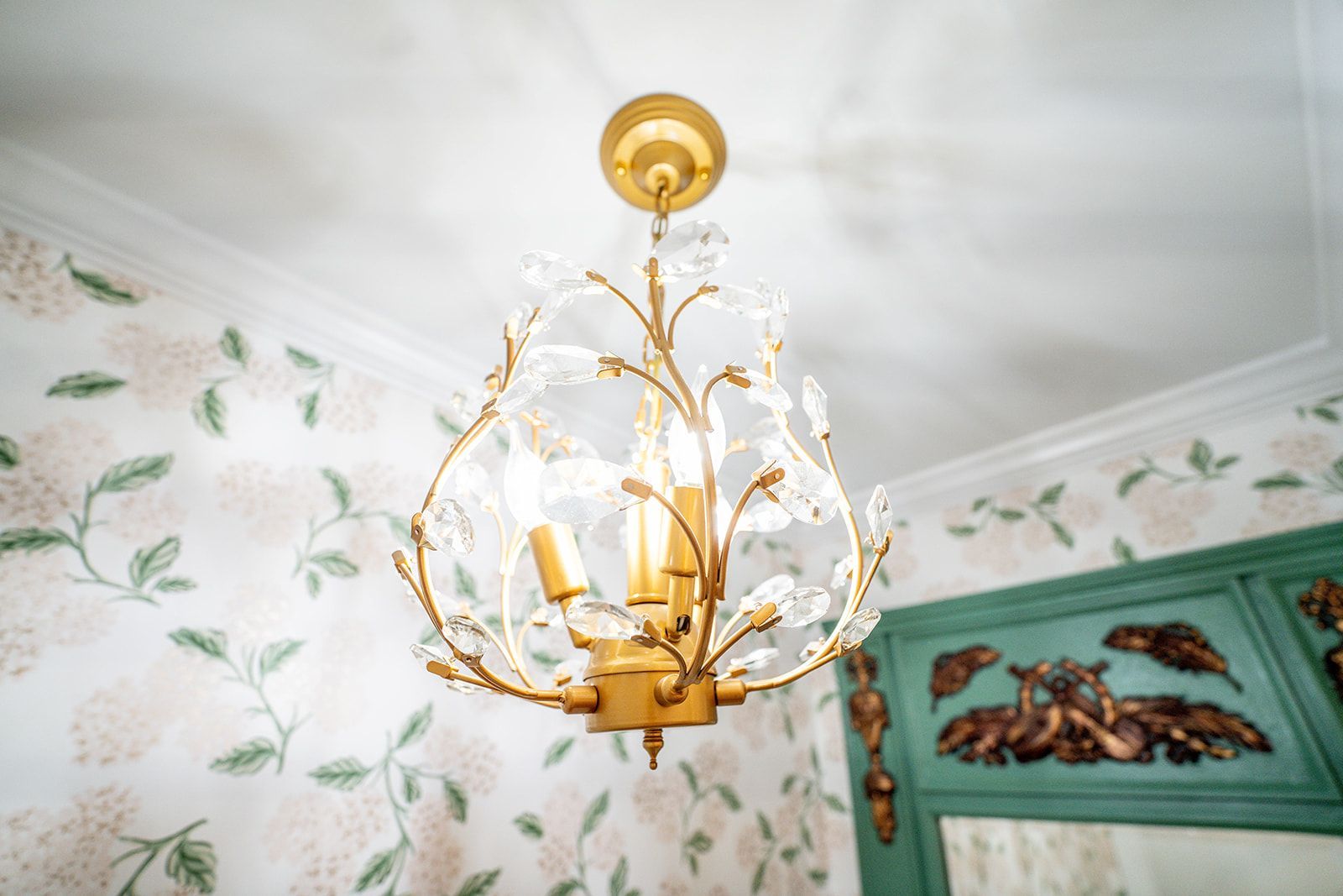 A gold chandelier is hanging from the ceiling in a room.