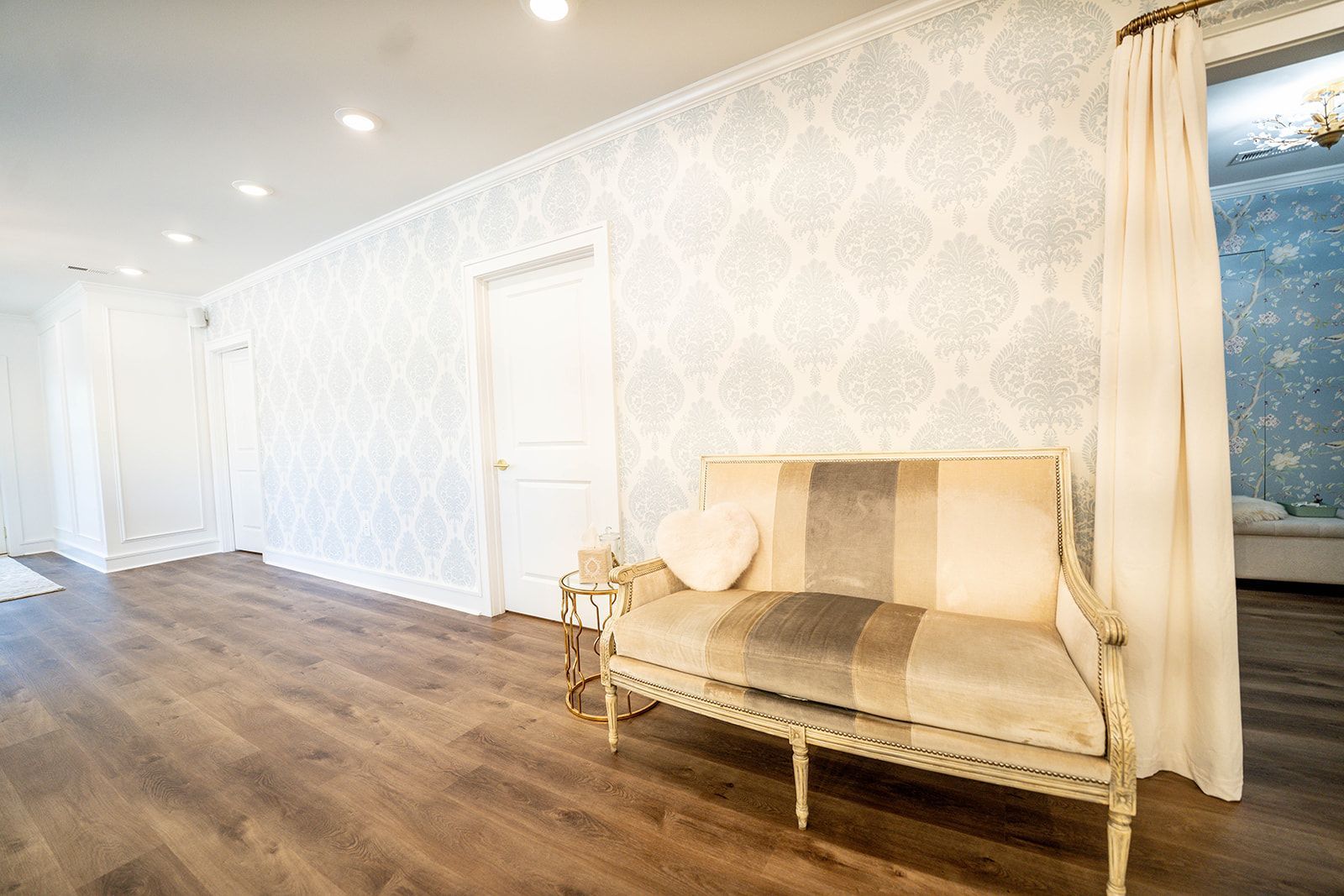 A couch is sitting in a hallway next to a door.