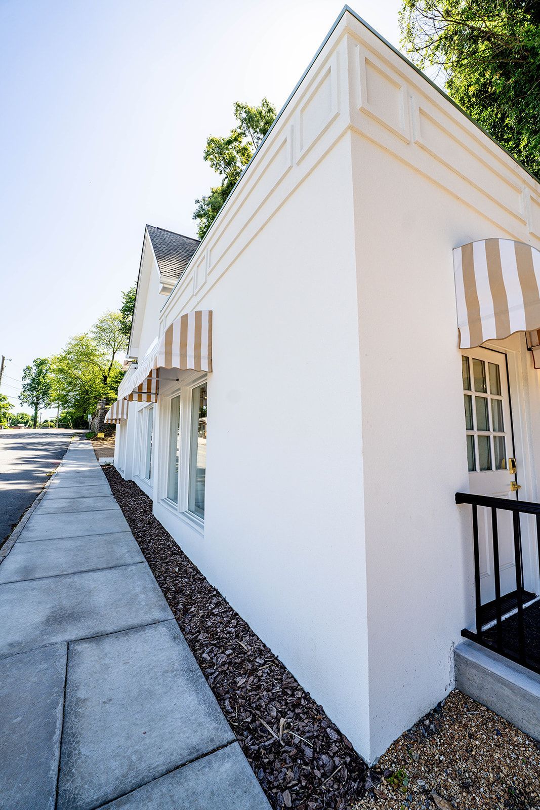 A white building with a striped awning on the side of it