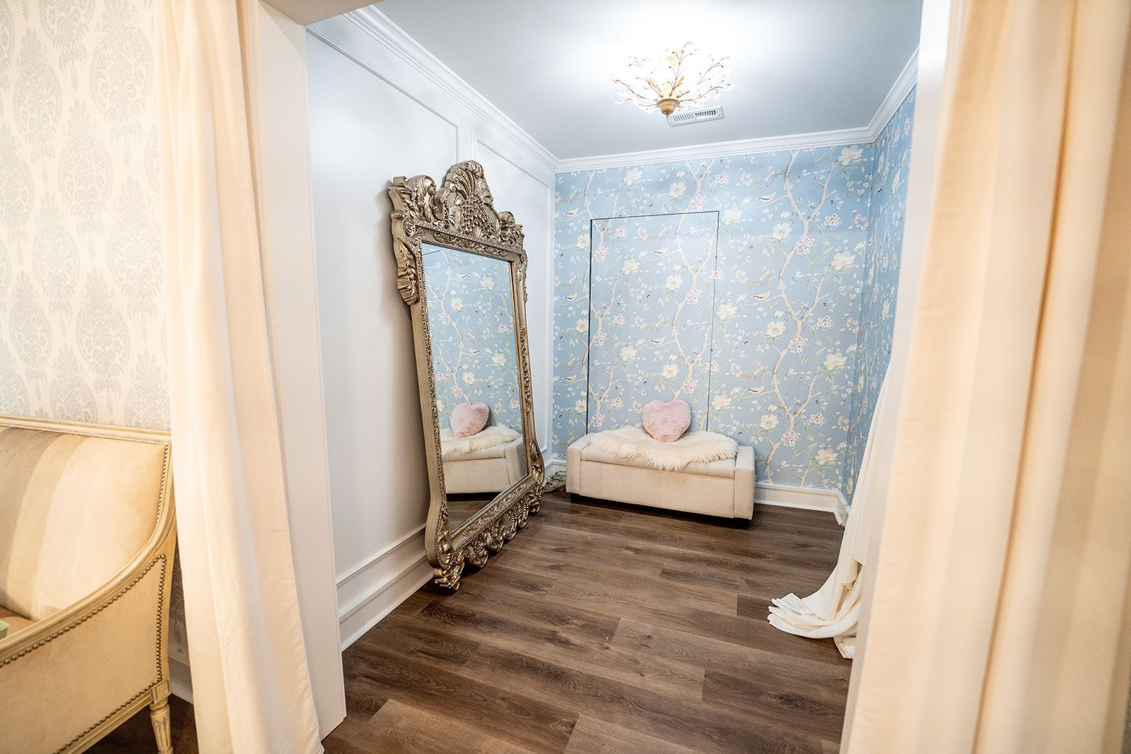 A dressing room with a large mirror and a bench.