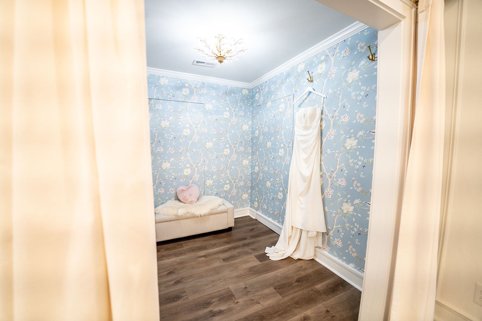 A wedding dress is hanging on a wall in a room.