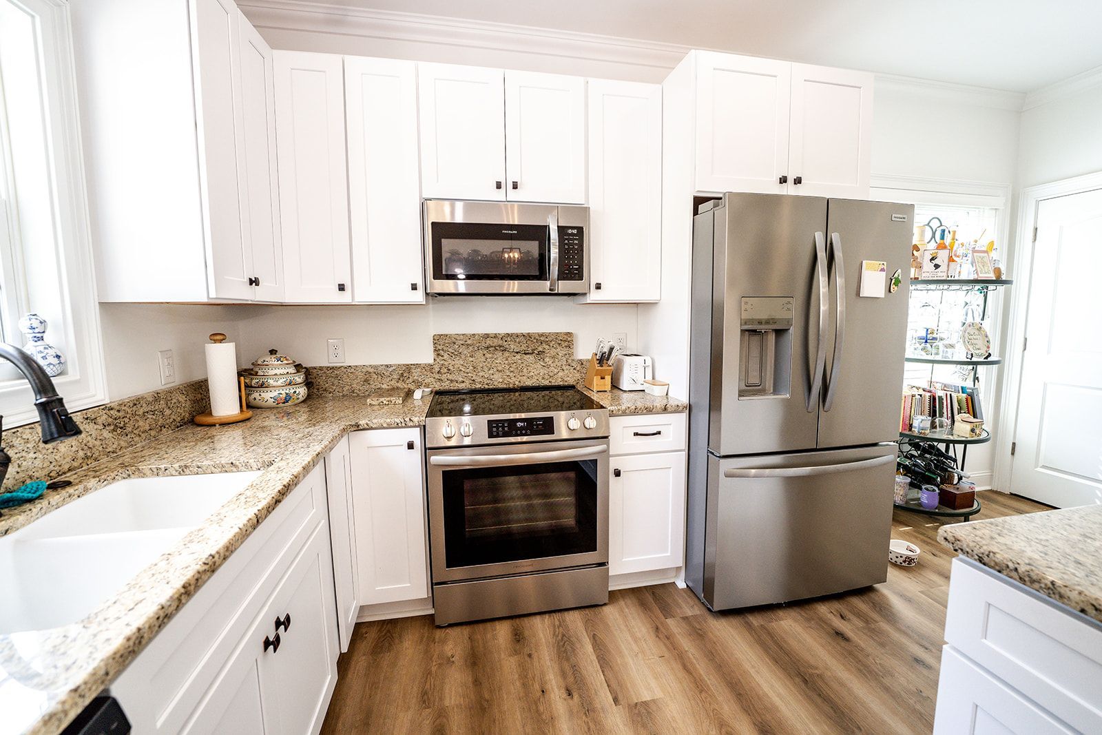 A kitchen with stainless steel appliances and white cabinets.
