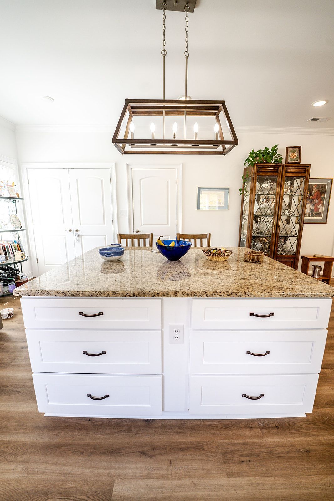 A kitchen with a large island and a chandelier hanging from the ceiling.