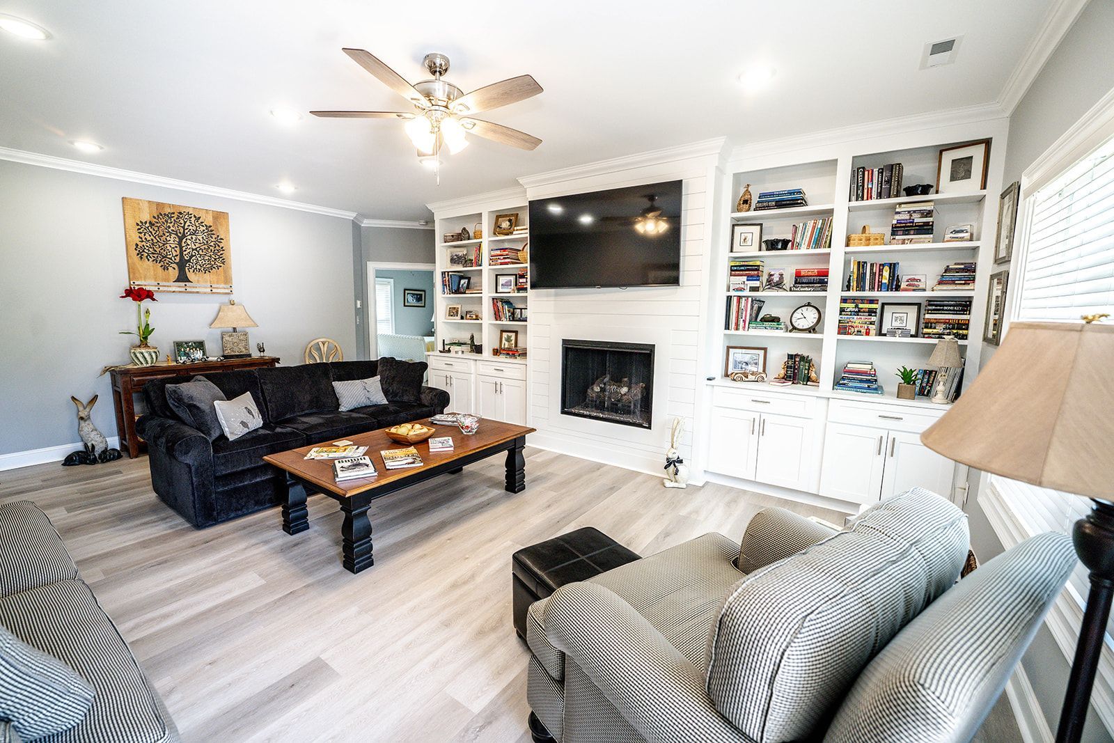 A living room with a couch , chair , coffee table and television.