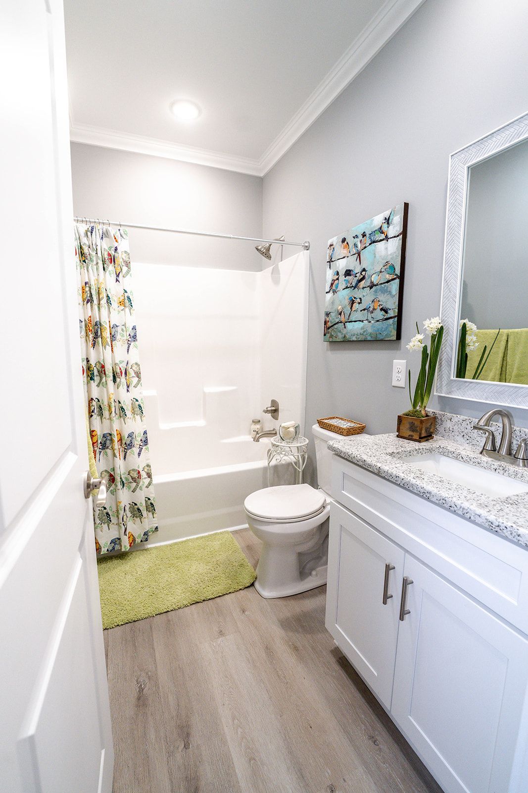 A bathroom with a toilet , sink , bathtub and mirror.