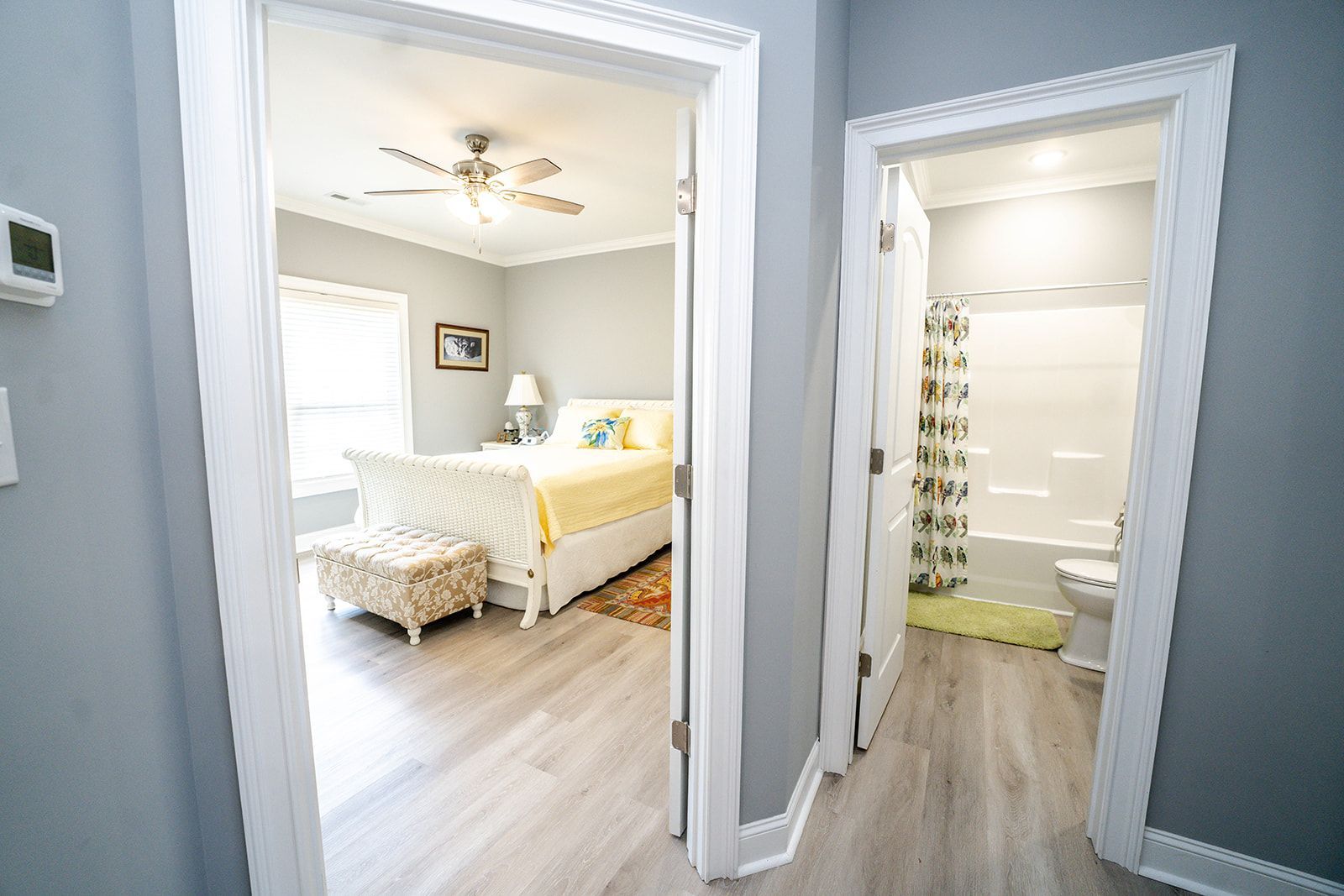 A bedroom with a king size bed and a bathroom with a walk in shower.