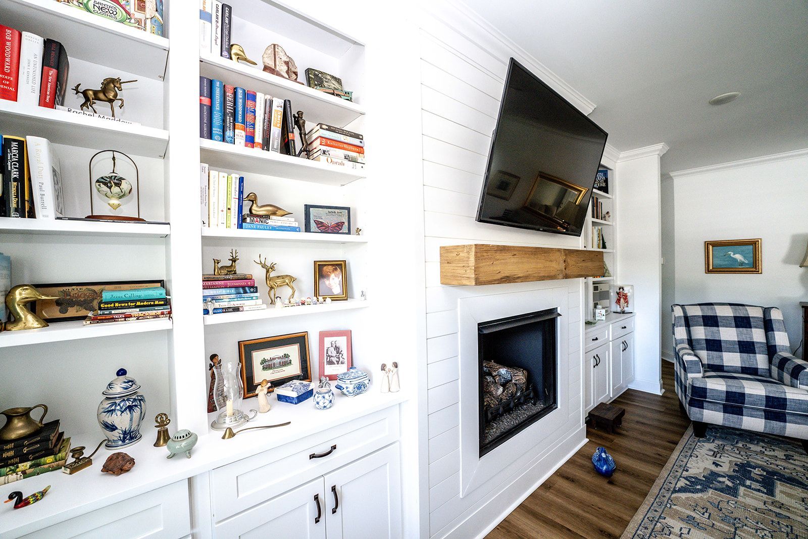 A living room with a fireplace and a flat screen tv on the wall.