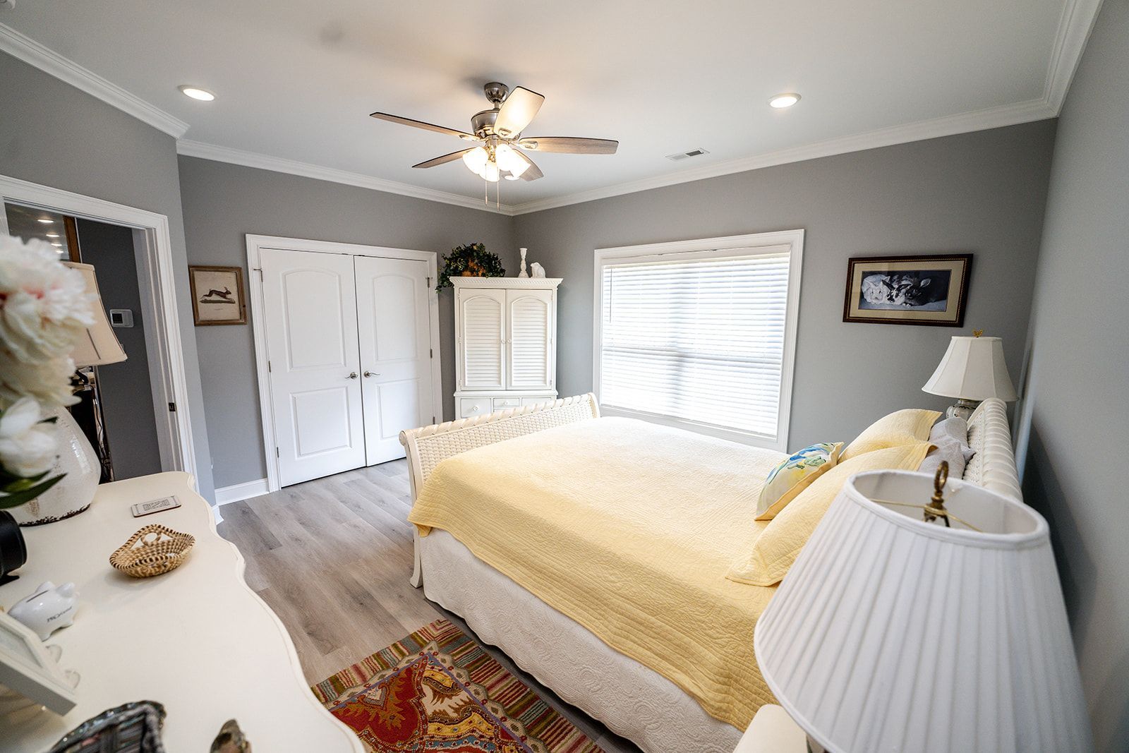 A bedroom with a large bed and a ceiling fan.
