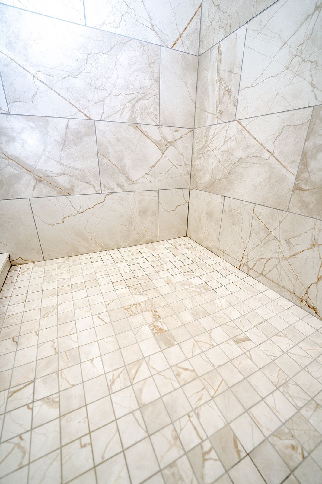 A bathroom with white tiles on the floor and walls.
