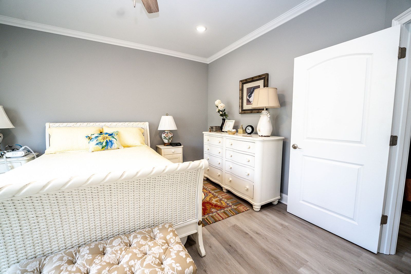A bedroom with a bed , dresser , nightstand and ceiling fan.