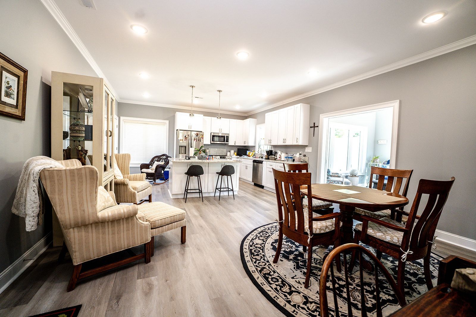 A living room and dining room in a house with a table and chairs.