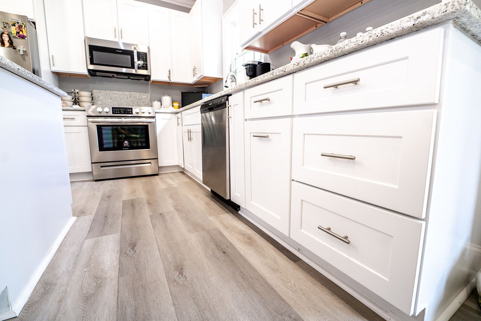 A kitchen with white cabinets and stainless steel appliances.