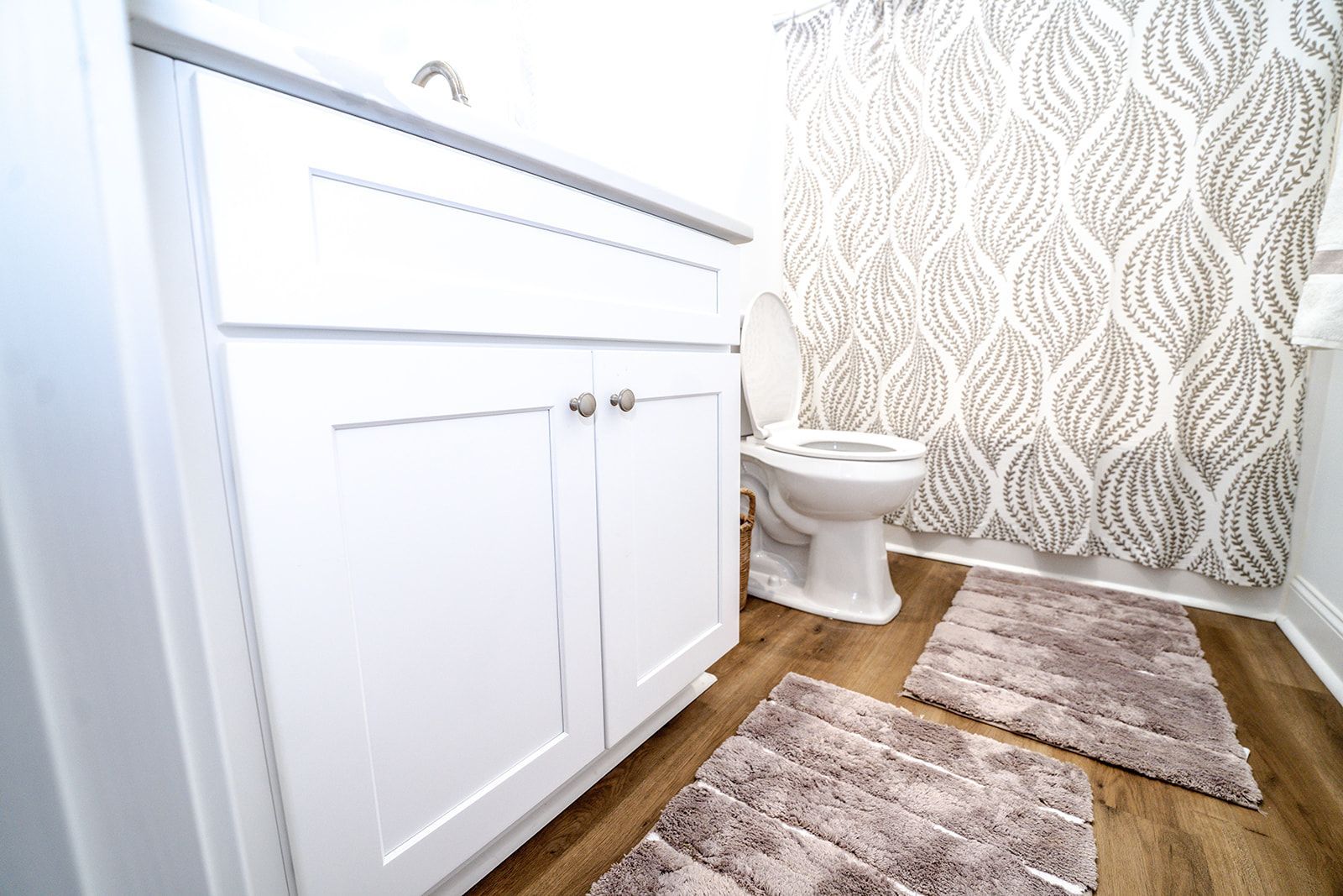 A bathroom with a toilet , sink , and shower curtain.