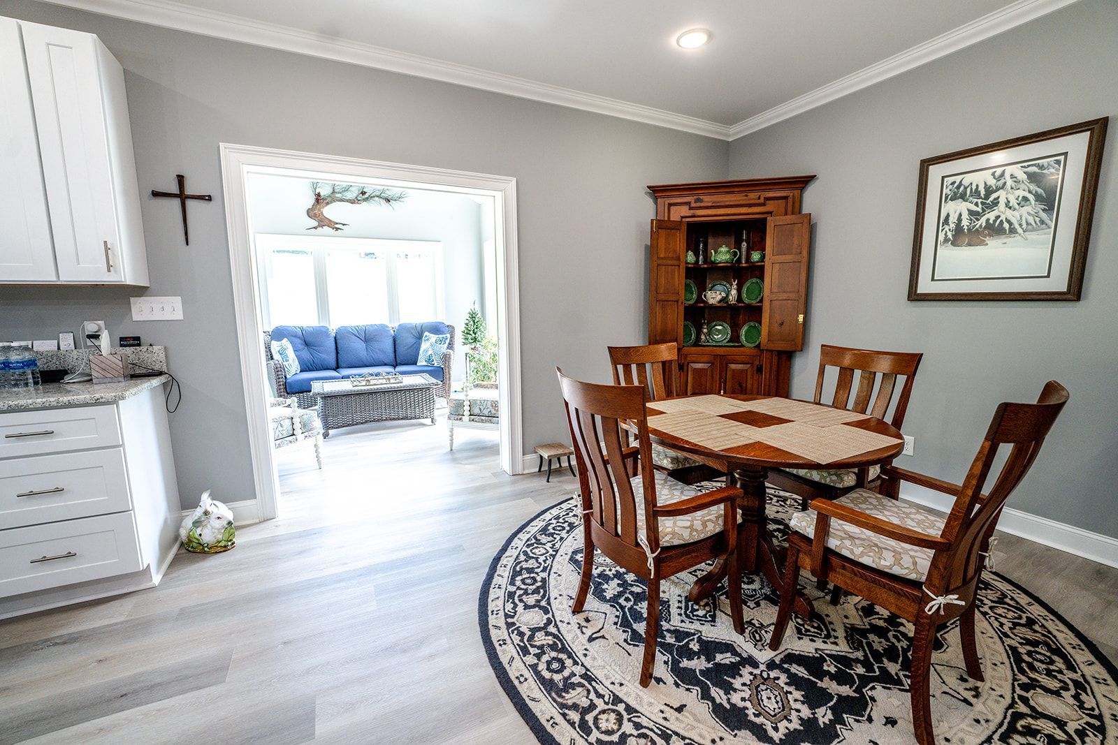 A dining room with a table and chairs and a rug.