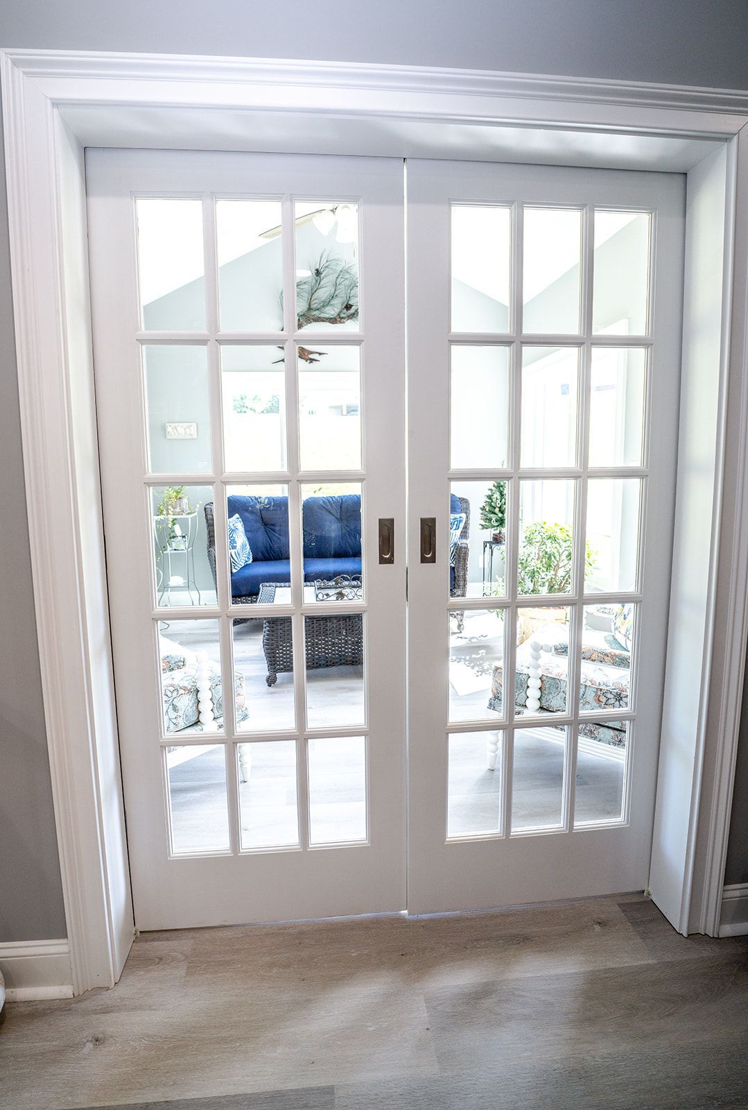 A pair of white french doors open to a living room.