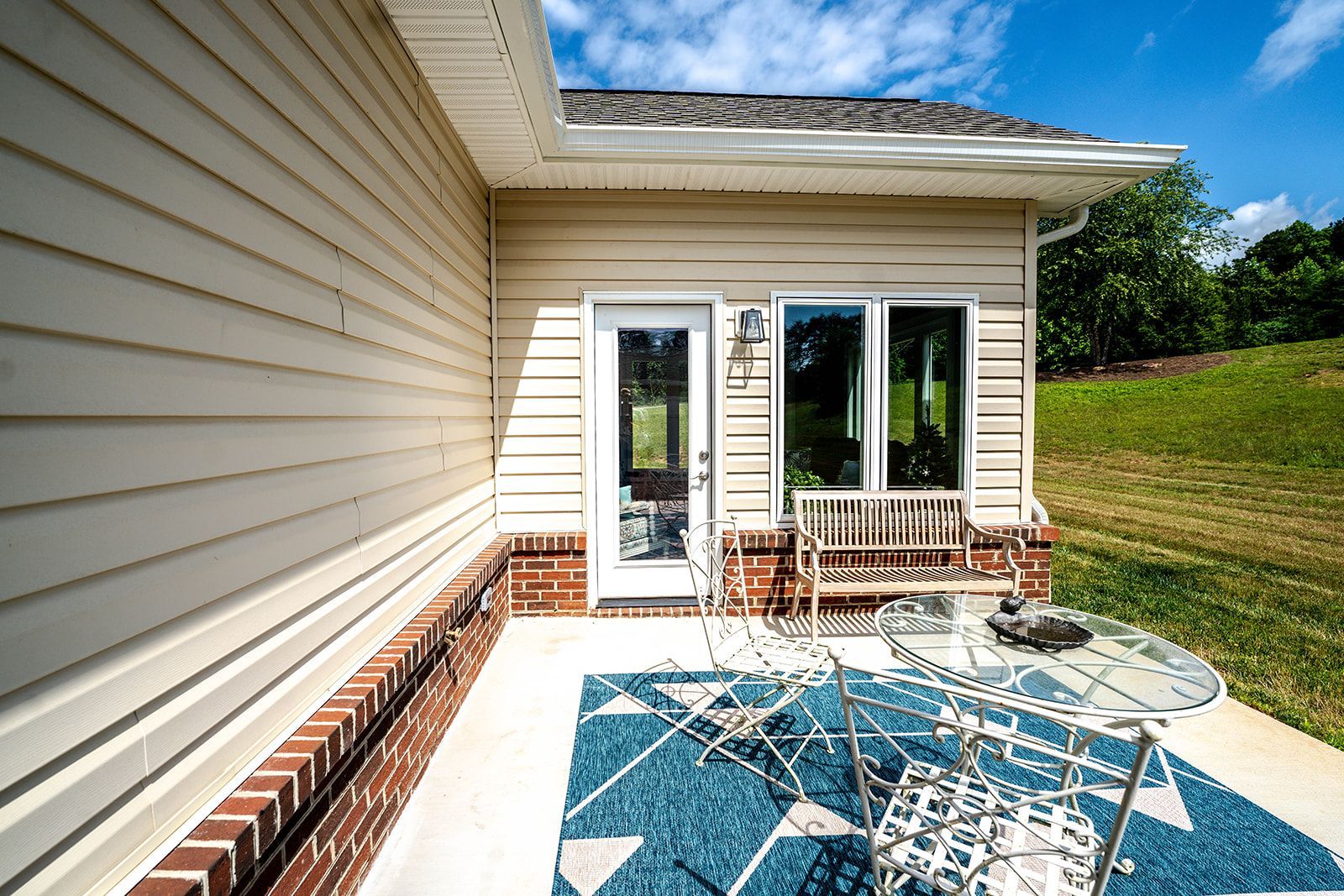 A patio with a table and chairs in front of a house.