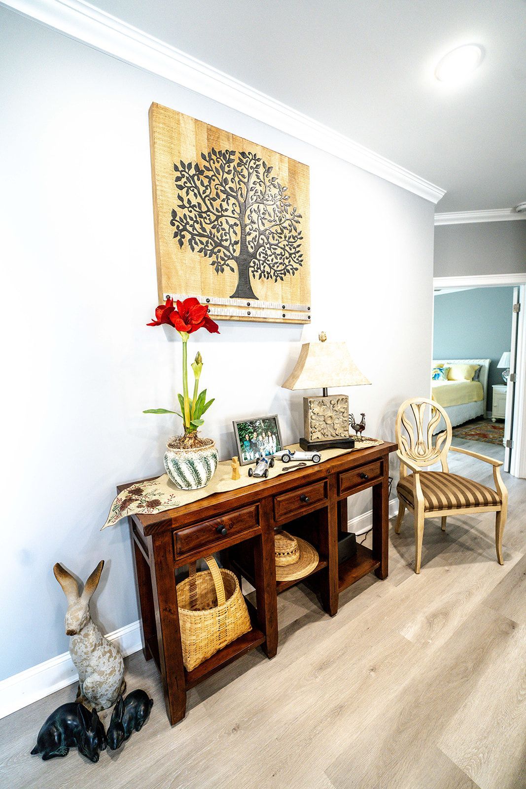 A hallway with a wooden table and chairs and a painting on the wall.